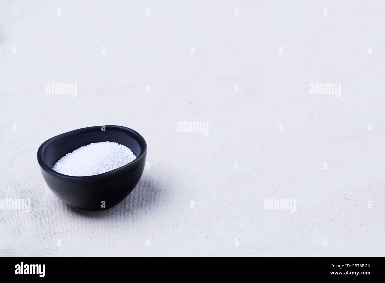 Une tasse de carbonate de soude sur un tissu de coton biologique beige, avec espace de copie Banque D'Images