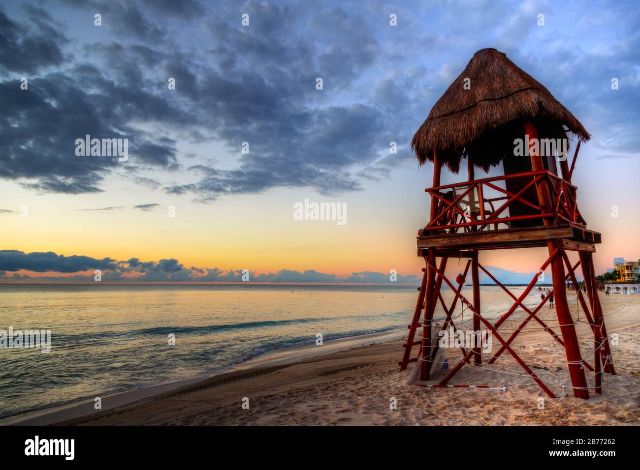 Lever du soleil sur les plages tropicales de la Riviera Maya près de Cancun, au Mexique, avec tour de sauveteur surplombant la mer des Caraïbes. Banque D'Images