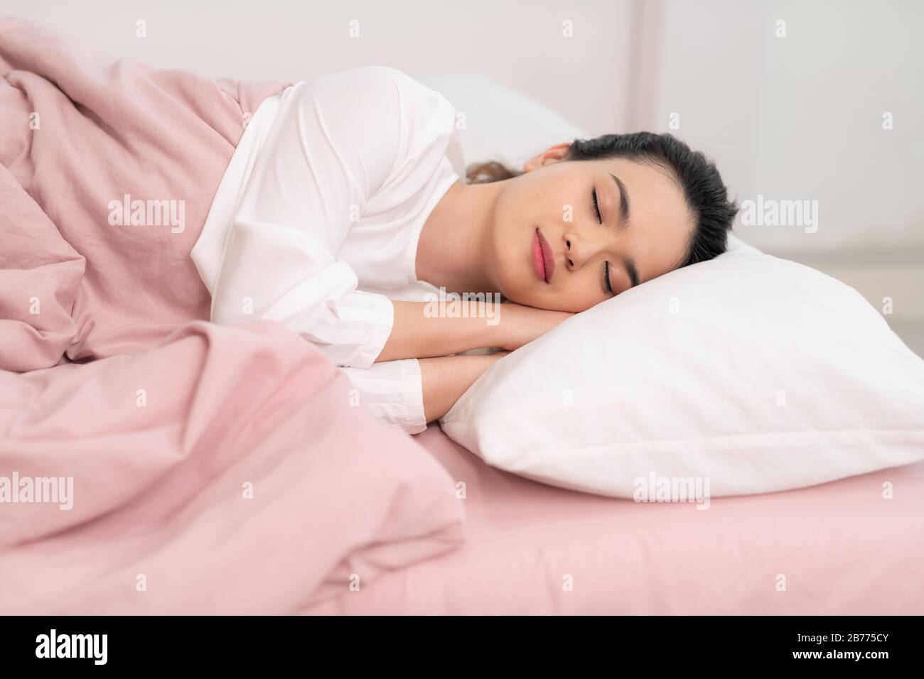 Joyeux Asian jeunes femmes de beauté dormant et sourire sur le lit le matin Banque D'Images