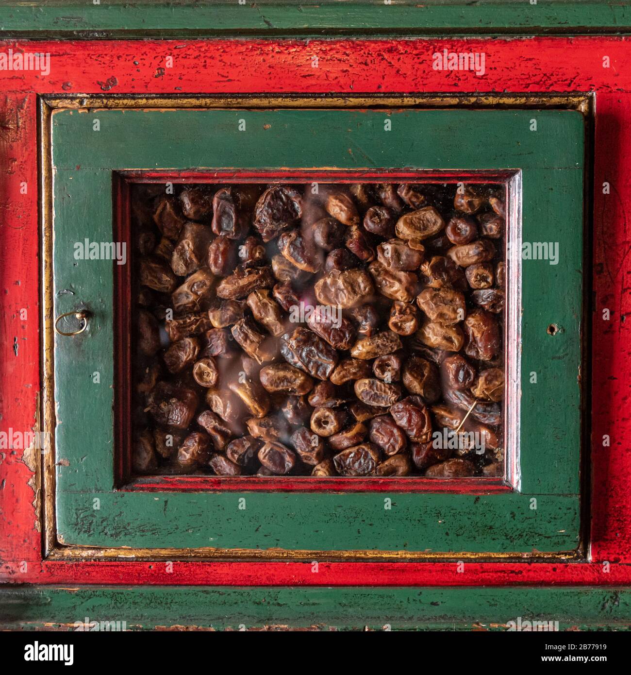 Mobilier en bois rouge avec détails verts, avec fenêtres pour voir le contenu des tiroirs à l'intérieur. Dans ce cas, figues sèches Banque D'Images