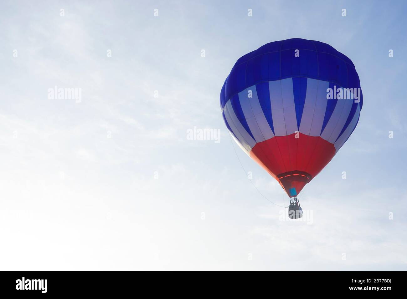 Un festival de montgolfière comprend des parapentes, des ballons à air chaud et d'autres transports aériens. Un parapente survole un ballon avant de partir. Banque D'Images