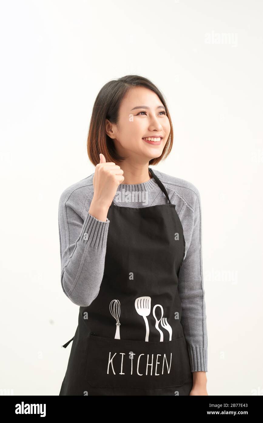 Une jeune femme de magasinier asiatique portant un tablier sur un fond blanc isolé, se faisant un geste heureux à la main. Banque D'Images
