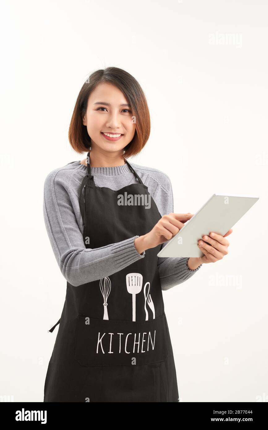 Employé de l'hypermarché avec tablier noir tenant une tablette moderne isolée sur fond blanc avec copyspace Banque D'Images