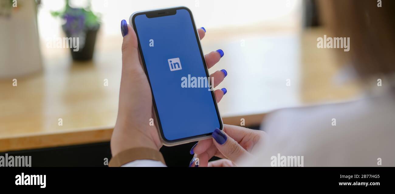 CHIANG mai, THAÏLANDE - 13 MARS 2020 : femme tenant iPhone avec écran Linkedin. LinkedIn est une application mobile pour la recherche d'emploi Banque D'Images