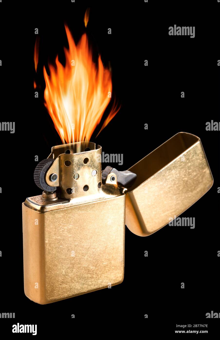 Brûlez un briquet à gaz en métal doré sur fond noir. Banque D'Images
