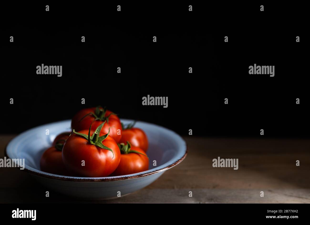 Fruits frais, délicieuse tomate sur fond sombre avec espace de copie. Banque D'Images