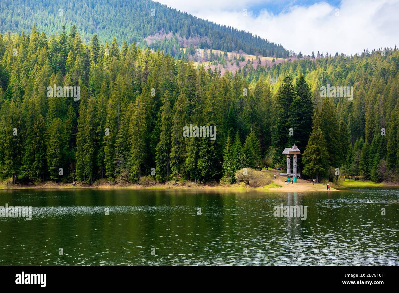 lac de montagne alpin au milieu de la forêt. beau temps ensoleillé avec des nuages moelleux sur le ciel bleu. paysage printanier dans une lumière aux applis. le corps de l'eau Banque D'Images