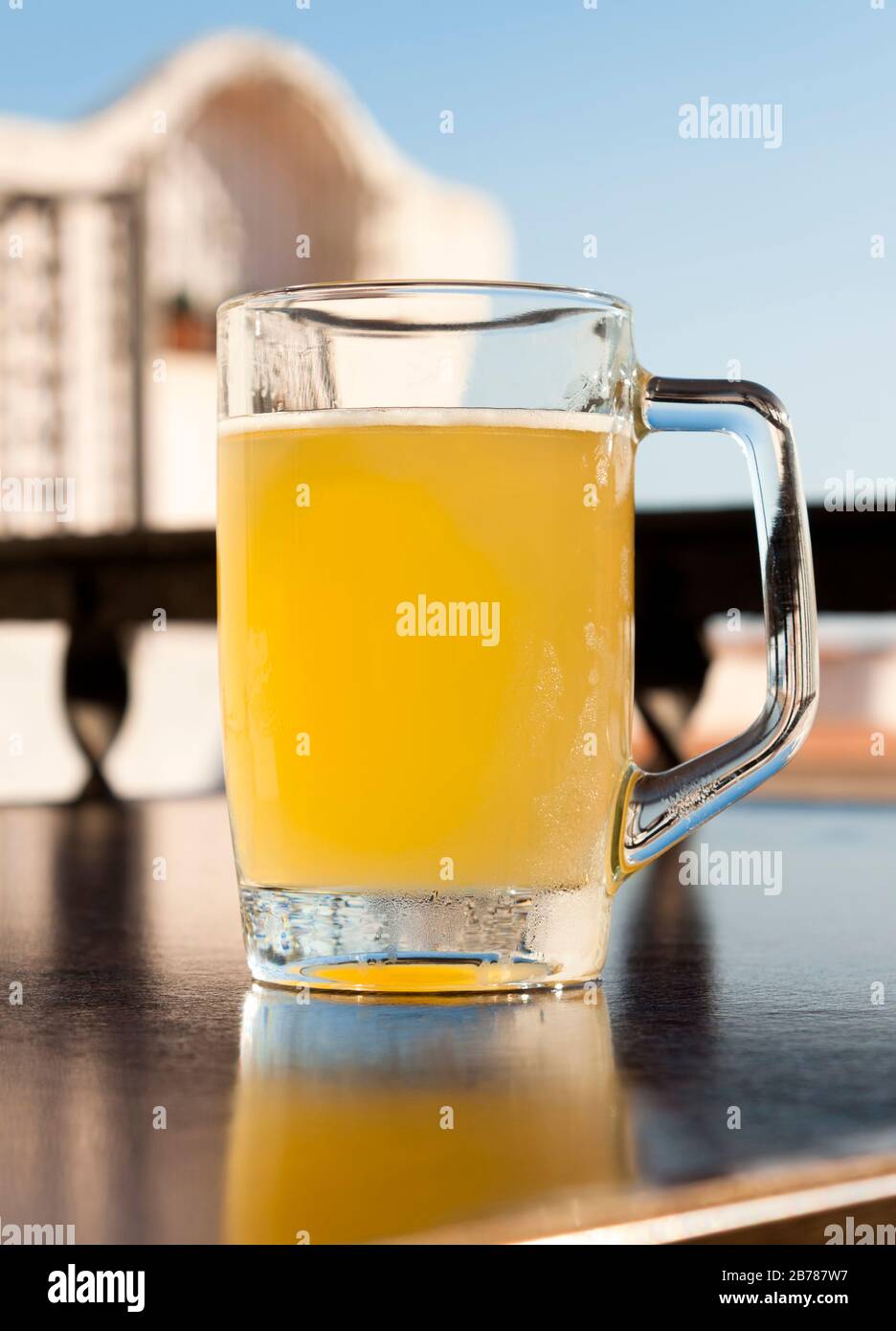 Verre de bière froide avec citron sur la table d'une terrasse dans un bar près de la mer Méditerranée en Espagne. Bâtiment typiquement espagnol méditerranéen sur bac Banque D'Images