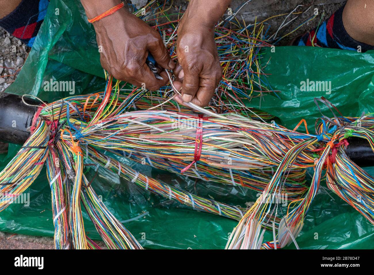 Technicien répare un câble multiconducteur de ligne téléphonique souterraine Banque D'Images
