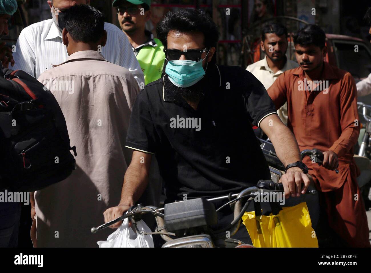 (200314) -- KARACHI, 14 mars 2020 (Xinhua) -- un homme portant un masque de visage fait une moto dans la ville portuaire pakistanaise du sud de Karachi le 14 mars 2020. Le gouvernement du Pakistan a annoncé de mettre à niveau ses mesures contre COVID-19 dans tout le pays après que 28 personnes ont testé le virus positif au cours des 17 derniers jours, a déclaré l'adjoint spécial au Premier ministre de la Santé Zafar Mirza aux médias ici vendredi soir. Le pays a interdit toutes sortes de rassemblements publics, y compris les festivals sportifs et culturels, les rassemblements récréatifs dans les cinémas et les théâtres, les cérémonies de mariage dans les salles ou les salles ouvertes Banque D'Images
