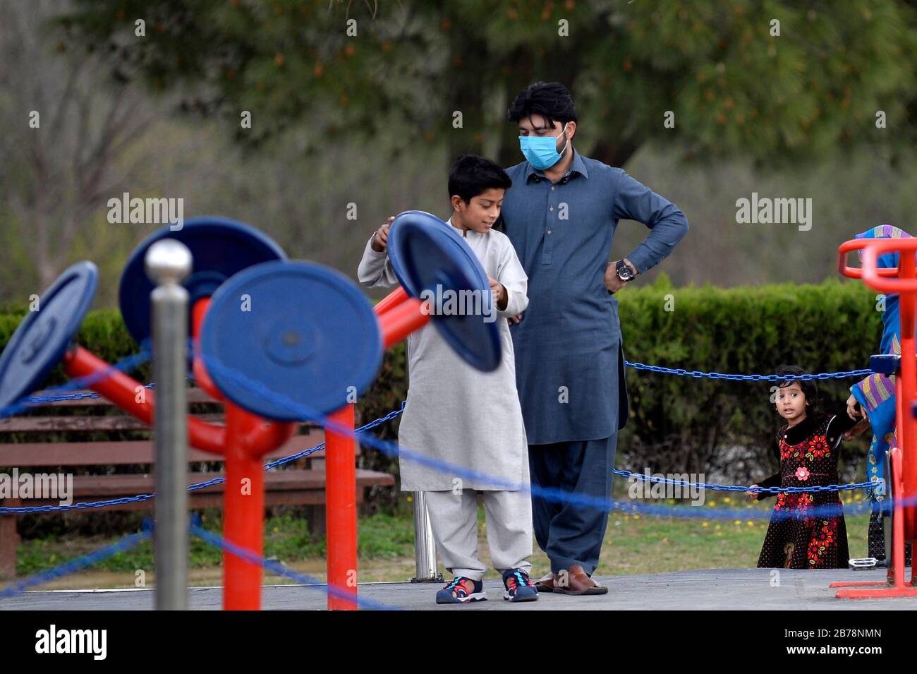 (200314) -- ISLAMABAD, le 14 mars 2020 (Xinhua) -- un homme portant un masque facial est vu dans un parc public à Islamabad, capitale du Pakistan, le 14 mars 2020. Le gouvernement du Pakistan a annoncé de mettre à niveau ses mesures contre COVID-19 dans tout le pays après que 28 personnes ont testé le virus positif au cours des 17 derniers jours, a déclaré l'adjoint spécial au Premier ministre de la Santé Zafar Mirza aux médias ici vendredi soir. Le pays a interdit toutes sortes de rassemblements publics, y compris les festivals sportifs et culturels, les rassemblements récréatifs dans les cinémas et les théâtres, les cérémonies de mariage dans les salles ou les salles ouvertes Banque D'Images
