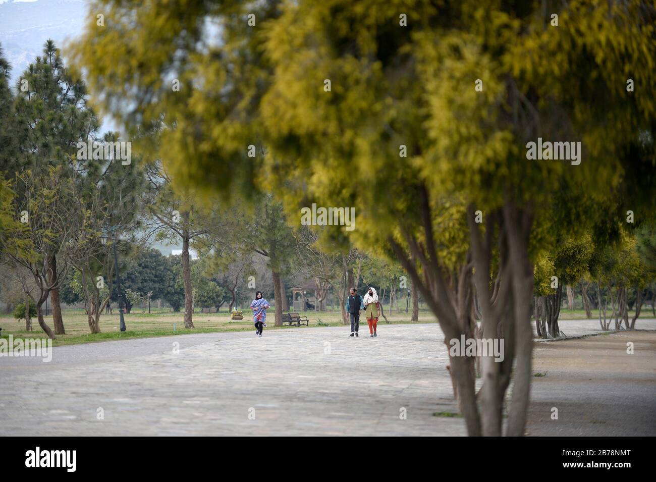 (200314) -- ISLAMABAD, 14 mars 2020 (Xinhua) -- quelques personnes marchent dans un parc public à Islamabad, capitale du Pakistan, 14 mars 2020. Le gouvernement du Pakistan a annoncé de mettre à niveau ses mesures contre COVID-19 dans tout le pays après que 28 personnes ont testé le virus positif au cours des 17 derniers jours, a déclaré l'adjoint spécial au Premier ministre de la Santé Zafar Mirza aux médias ici vendredi soir. Le pays a interdit toutes sortes de rassemblements publics, y compris les festivals sportifs et culturels, les rassemblements récréatifs dans les cinémas et les théâtres, les cérémonies de mariage dans les salles ou les lieux ouverts, les réunions Banque D'Images