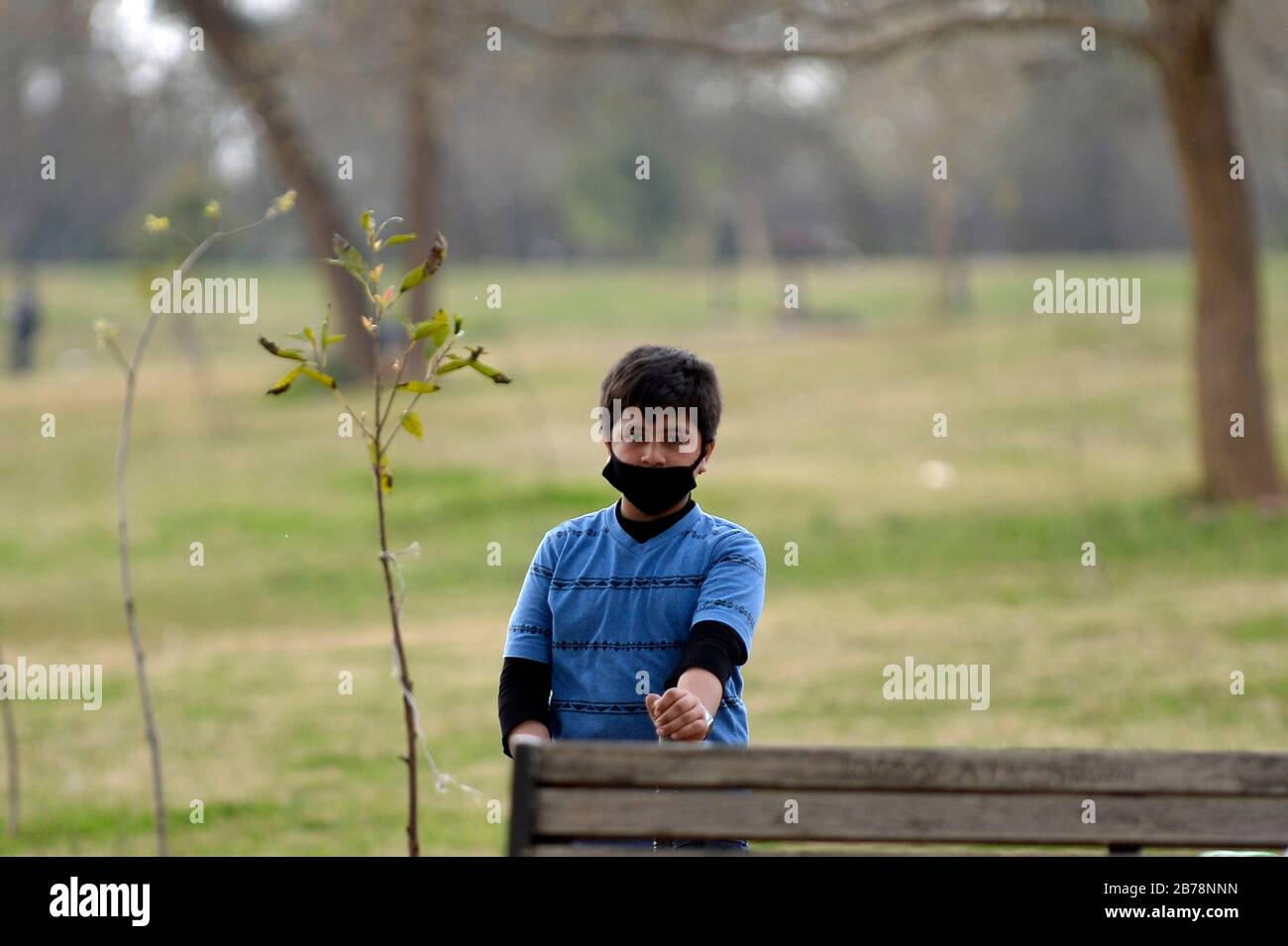 (200314) -- ISLAMABAD, le 14 mars 2020 (Xinhua) -- un garçon portant un masque facial est vu dans un parc public d'Islamabad, capitale du Pakistan, le 14 mars 2020. Le gouvernement du Pakistan a annoncé de mettre à niveau ses mesures contre COVID-19 dans tout le pays après que 28 personnes ont testé le virus positif au cours des 17 derniers jours, a déclaré l'adjoint spécial au Premier ministre de la Santé Zafar Mirza aux médias ici vendredi soir. Le pays a interdit toutes sortes de rassemblements publics, y compris les festivals sportifs et culturels, les rassemblements récréatifs dans les cinémas et les théâtres, les cérémonies de mariage dans les salles ou les salles ouvertes Banque D'Images