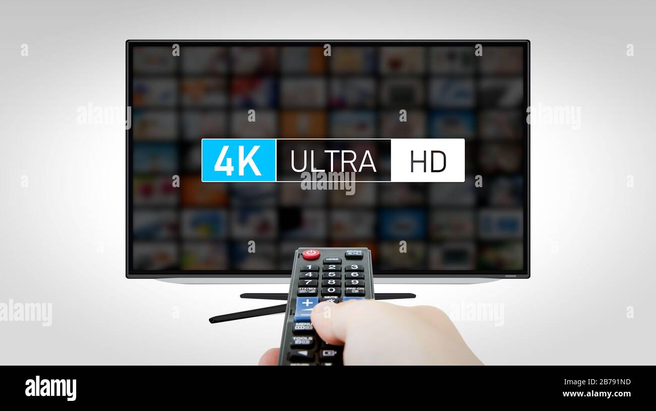 Télévision haute résolution 4 Ko. Concept multimédia TV. Main avec télécommande Banque D'Images