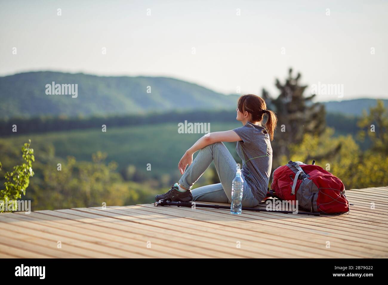 jeune femme assise sur un point de vue élevé en montagne, en regardant à distance. nature, détente, remplissage avec concept d'énergie Banque D'Images