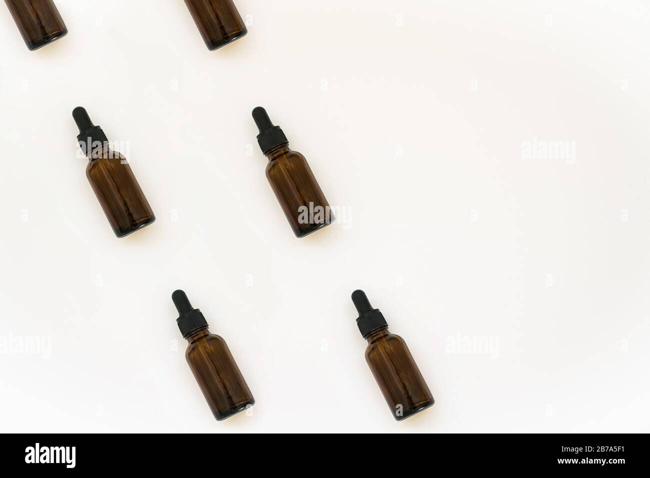 Motifs de bouteilles en verre pour cosmétiques naturels. Concept de médecine. Bocaux à huile essentielle isolés sur fond blanc. Vue de dessus ou de la couche plate. Banque D'Images