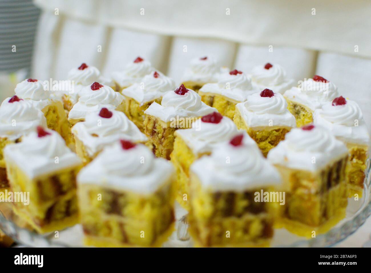 gâteaux éponge carrés jaunes au chocolat et à la cerise avec baies sur le dessus Banque D'Images