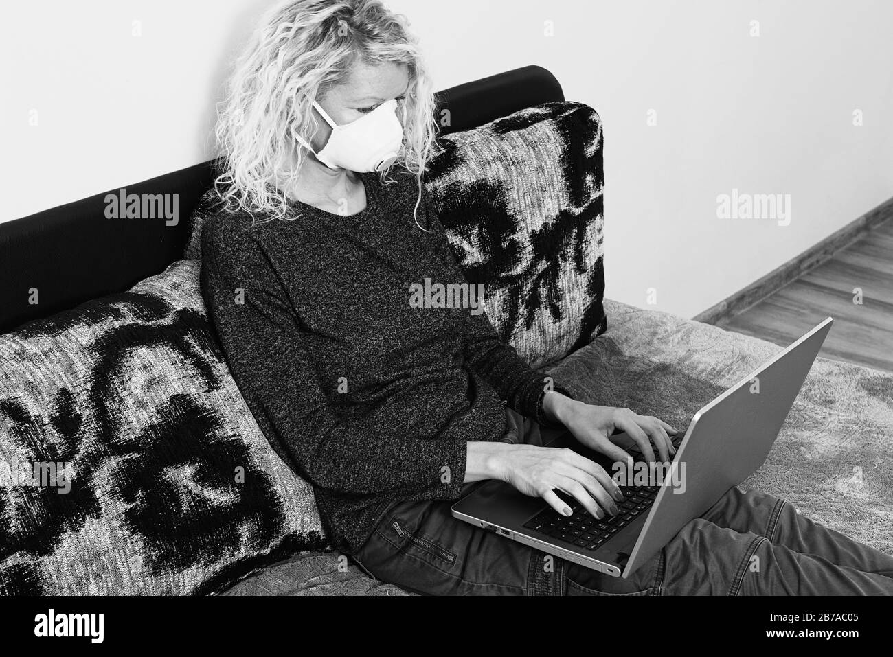 Femme en quarantaine pour Coronavirus portant un masque de protection et travaillant intelligemment Banque D'Images