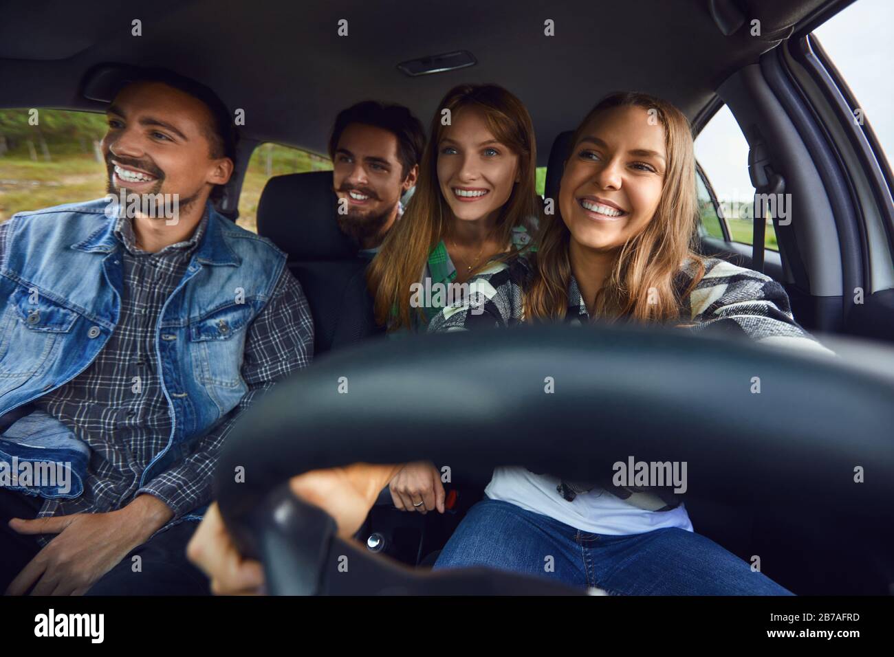 Un groupe d'amis sont heureux au volant d'une voiture. Banque D'Images