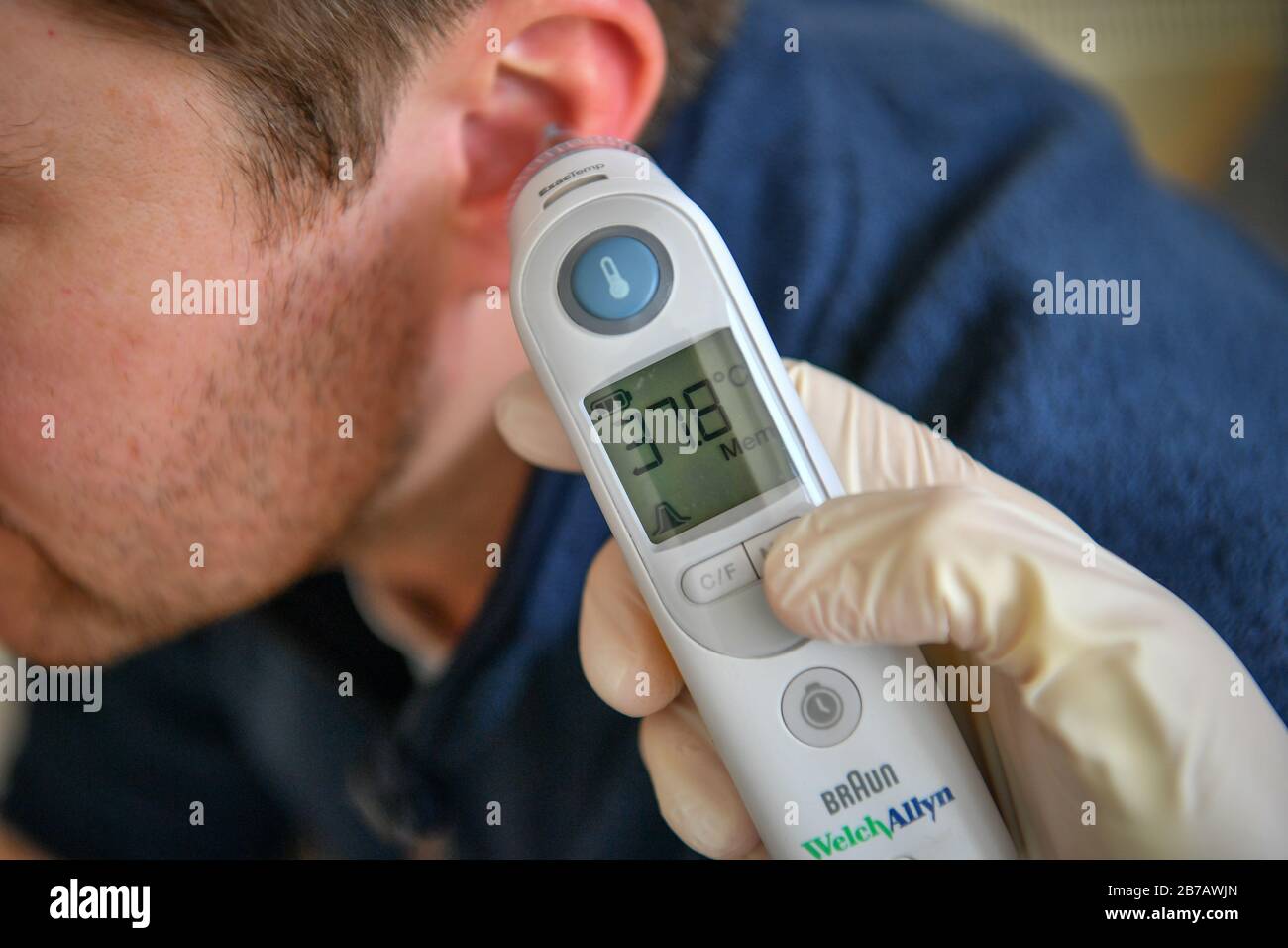 Image POSÉE PAR MODELA température corporelle de 37,8 degrés Celsius est  enregistrée sur un homme à l'aide d'un thermomètre tympanique. Photo PA.  Date De L'Image: Samedi 14 Mars 2020. Crédit photo devrait
