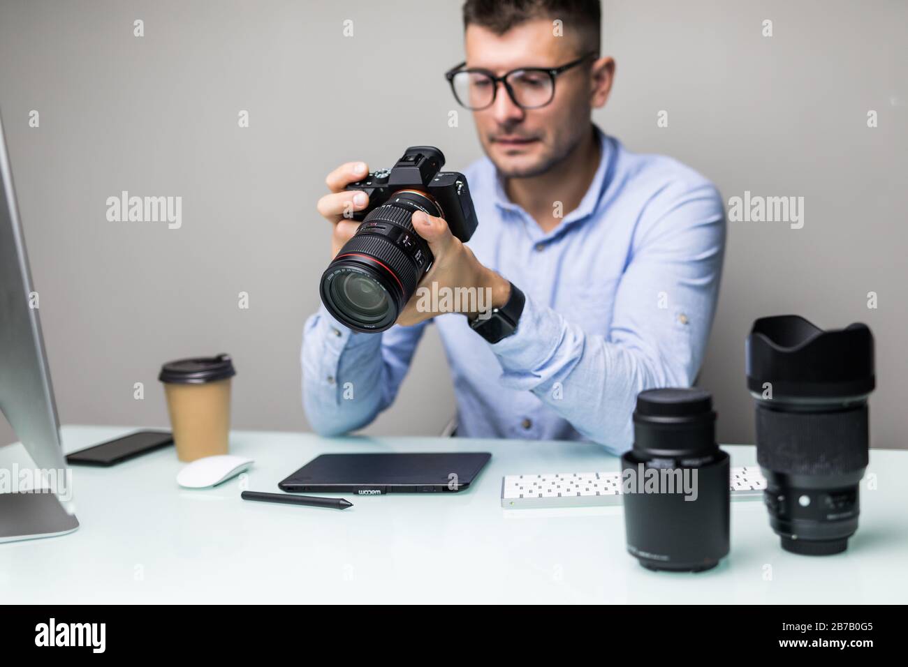 Le photographe charge des photos de son appareil photo sur l'ordinateur Banque D'Images