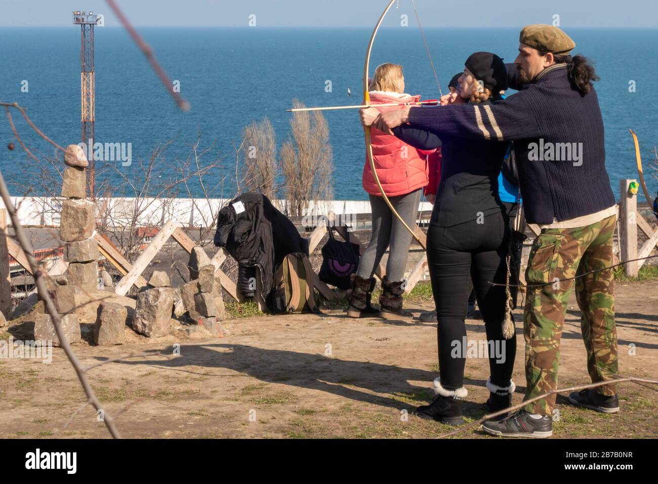 Un instructeur masculin enseigne un tir à l'arc de femme. 2020.03.01. Odessa. Ukraine Banque D'Images