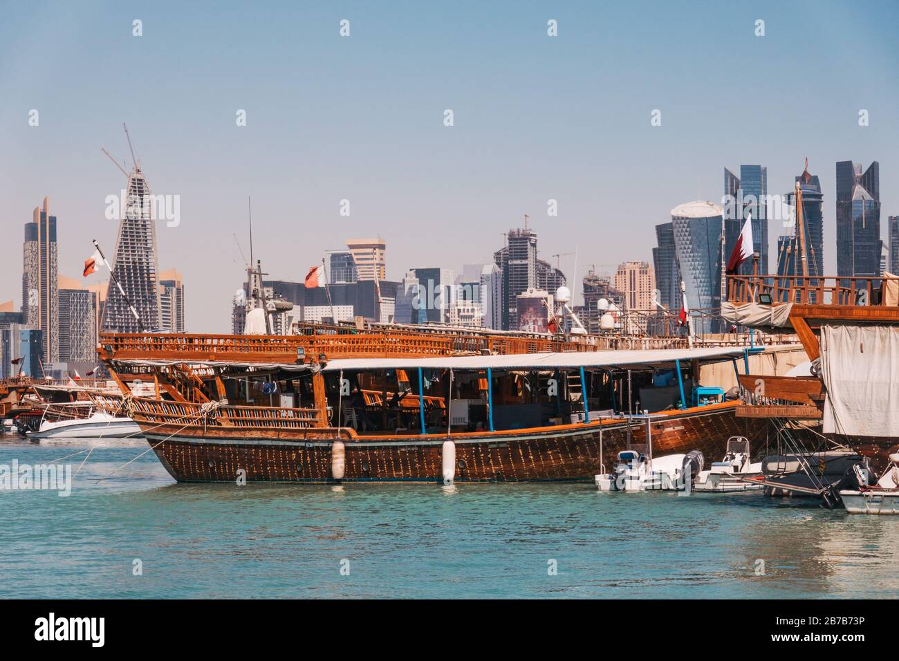 Des bateaux à hocher garés au port de Dhow avec le centre-ville de la financwial visible derrière, un matin d'été à Doha, Qatar Banque D'Images