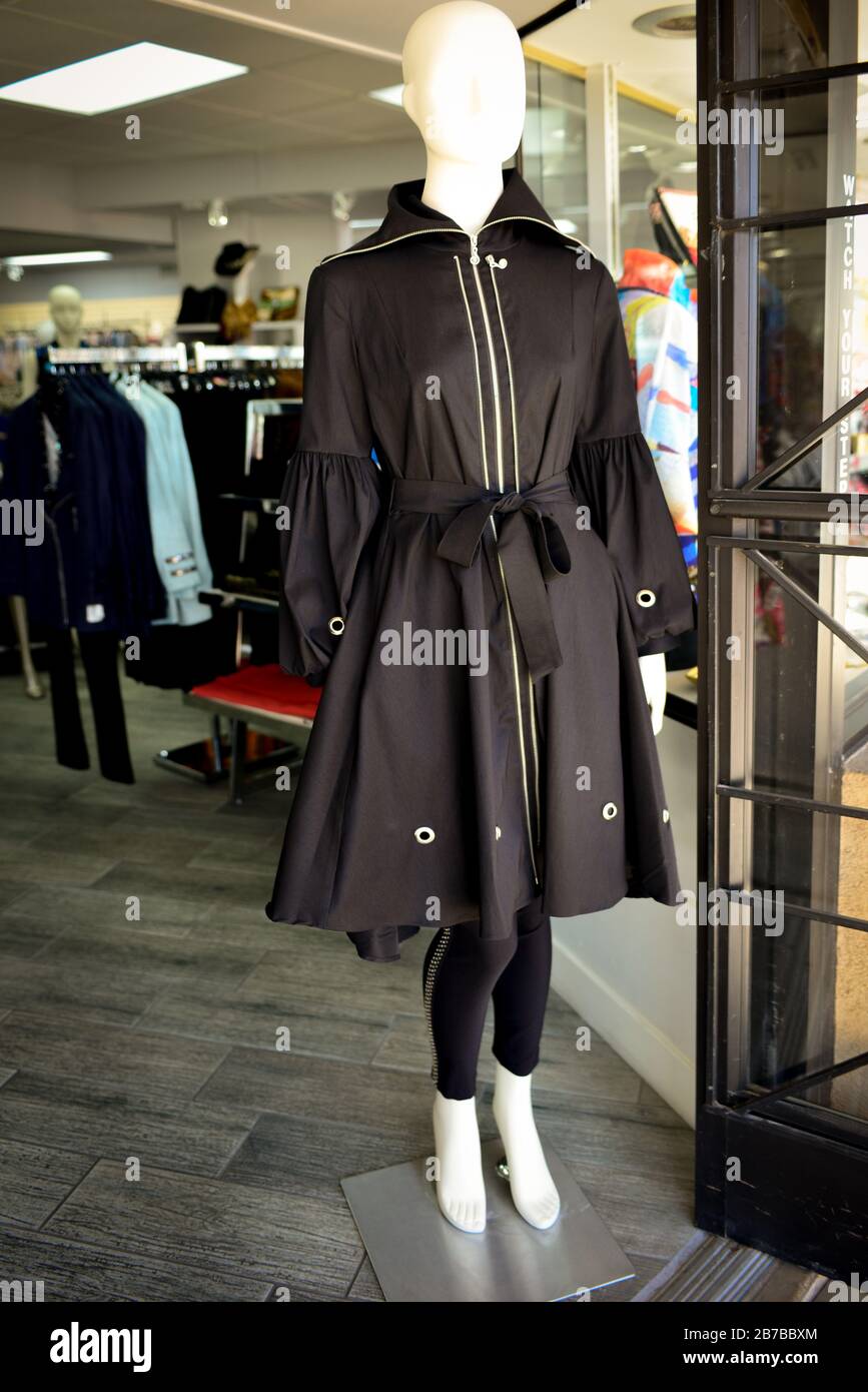 Un mannequin sans visage modélise un trench noir stylisé à l'entrée de la boutique Dames Fashion dans la vieille ville de Scottsdale, AZ, États-Unis Banque D'Images