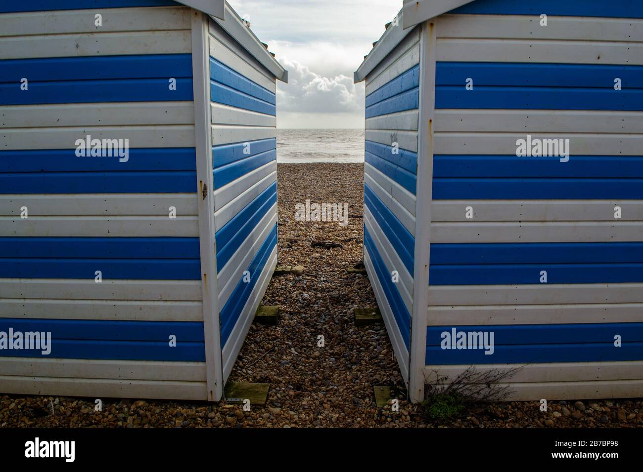 Un aperçu de la mer lors d'une journée d'hiver nuageux, entre deux huttes de plage sur la plage Banque D'Images