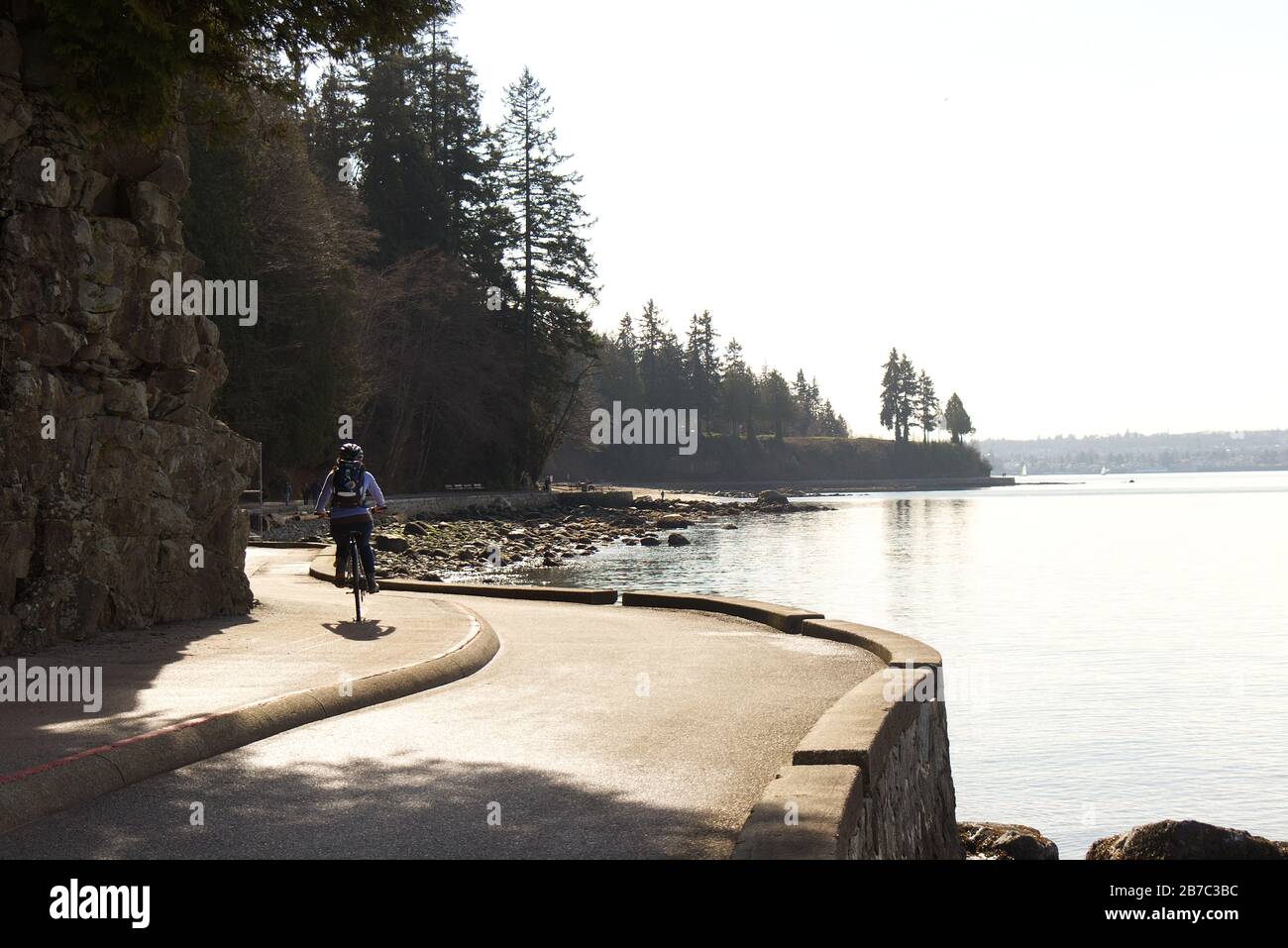 Vancouver, Canada - 21 février 2020 : une femme est sur le sentier côtier près de la troisième plage du parc Stanley pendant la belle journée ensoleillée Banque D'Images