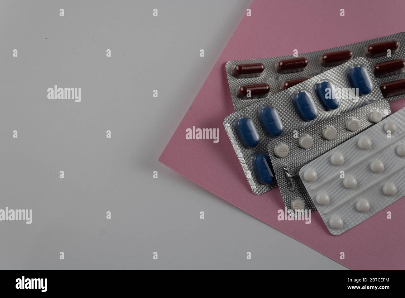 image avec différents types de médicaments emballés en comprimés avec fond blanc et rose Banque D'Images