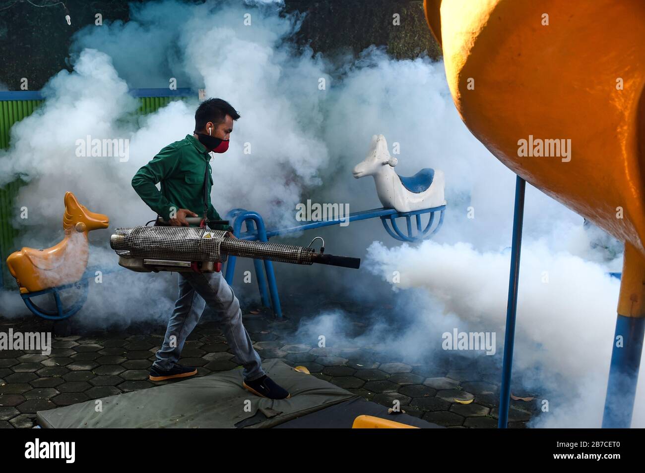 Jakarta, Indonésie. 15 mars 2020. Un travailleur vaporise de la brume anti-moustiques dans une aire de jeux de la Pangudi Luhur School Foundation, Jakarta, Indonésie, 15 mars 2020. La dengue est une maladie transmise par les moustiques causée par l'un des quatre virus de dengue étroitement liés. La maladie est transmise par la piqûre d'un moustique aedes, en particulier d'un moustique aedes aegypti, infecté par un virus de la dengue. Le contrôle du nombre d'adultes et de larves de moustiques était essentiel pour réduire la transmission des virus de la dengue. Crédit: Agung Kuncahya B./Xinhua/Alay Live News Banque D'Images