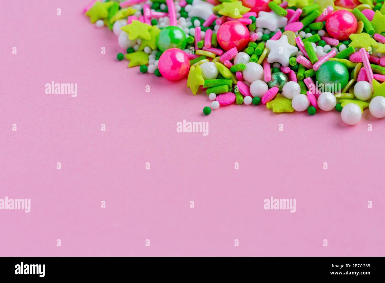 Pois saupoudrés de sucre multicolores, décoration pour gâteau et bekery sur fond rose. Pâques Banque D'Images