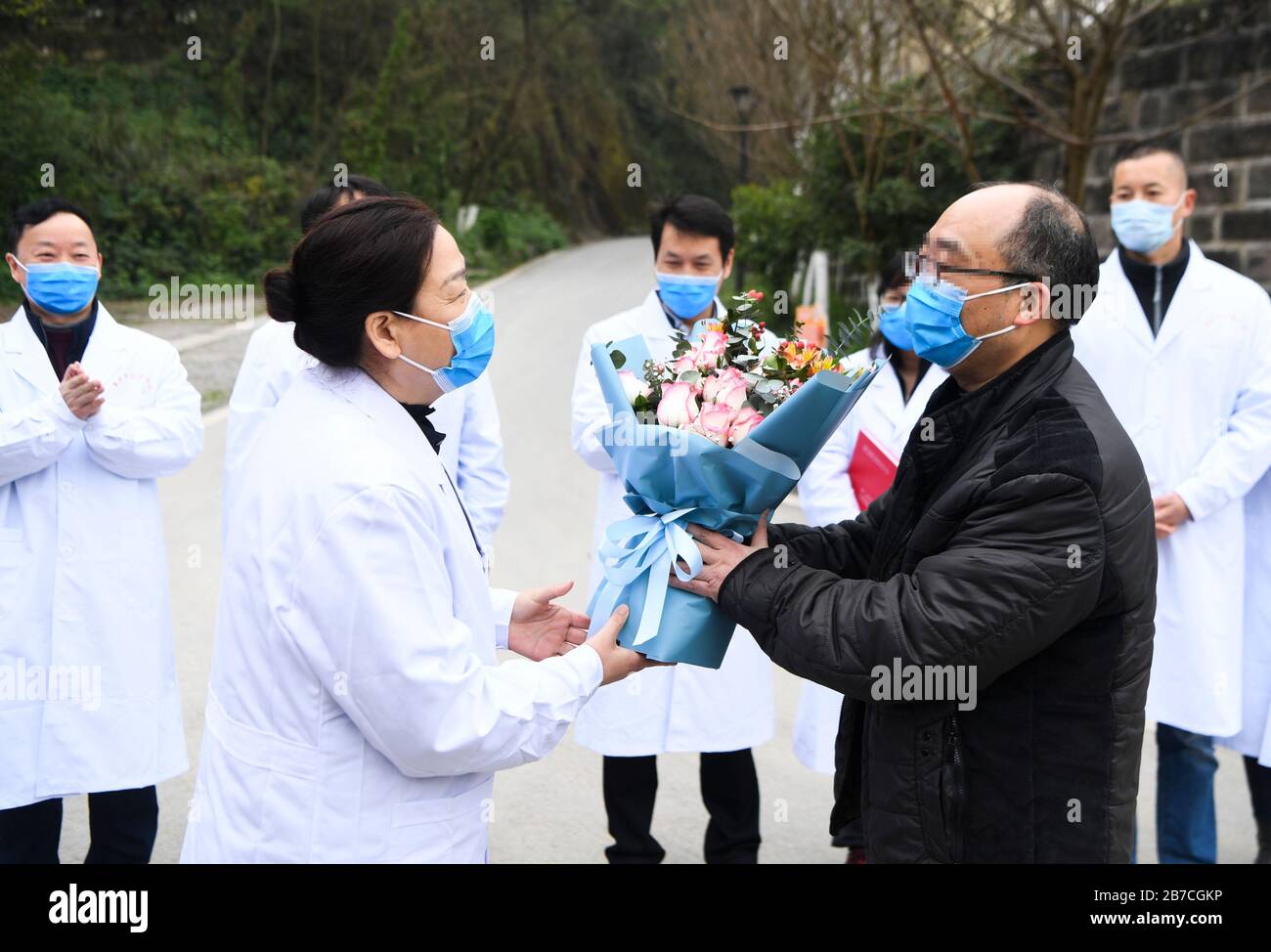 Chongqing, Chine. 15 mars 2020. Un travailleur médical présente un bouquet de fleurs à un patient retrouvé au Chongqing public Health Centre, dans le sud-ouest de la Chine, le 15 mars 2020. Le dernier patient diagnostiqué avec la nouvelle maladie du coronavirus (COVID-19) a été guéri et libéré du centre, ce qui porte à zéro le nombre de patients traités dans les hôpitaux de COVID-19 à Chongqing. Crédit: Wang Quinchao/Xinhua/Alay Live News Banque D'Images