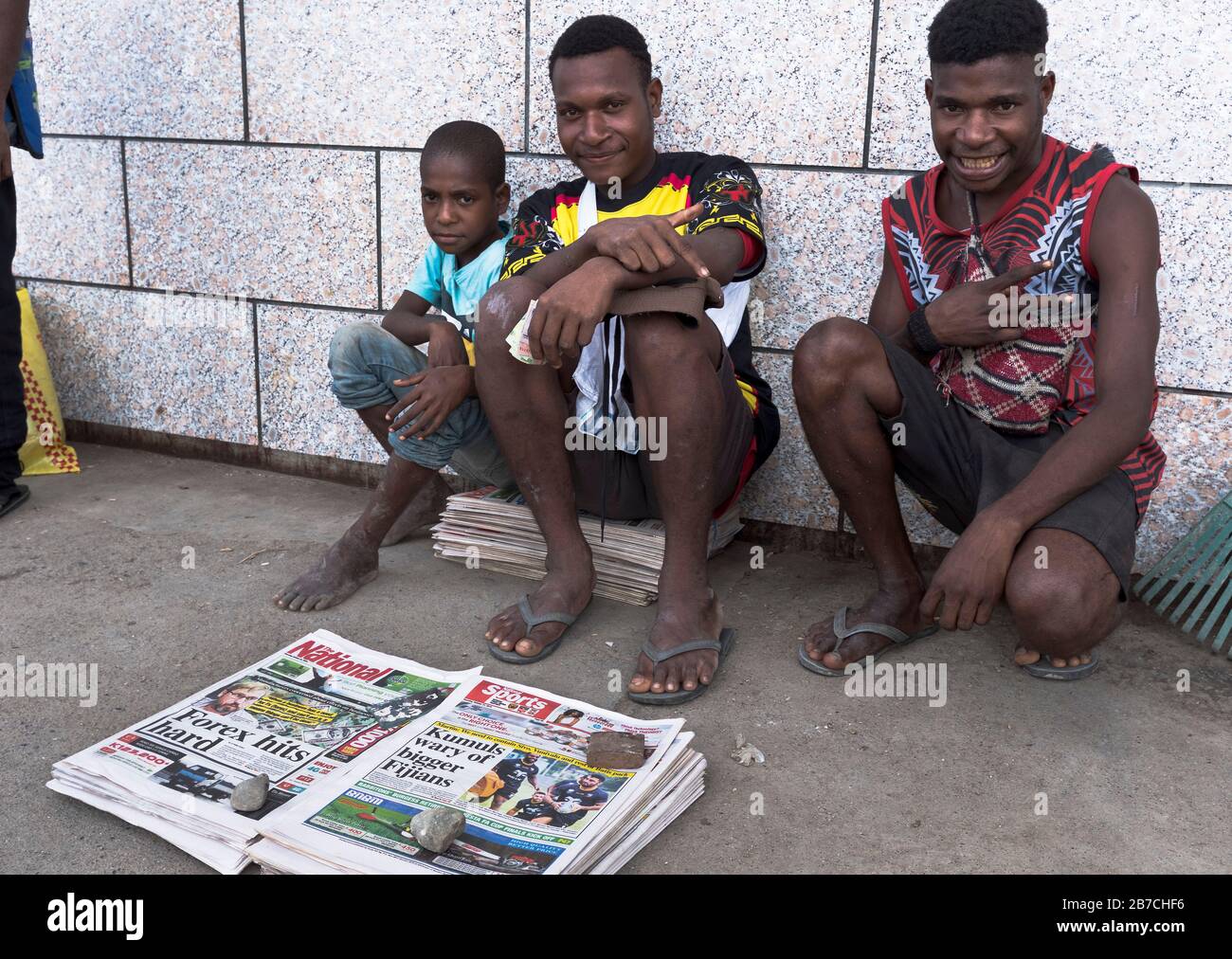 dh vendeurs de journaux MADANG PAPOUASIE NOUVELLE GUINÉE hommes locaux vendant des journaux vendeur homme souriant garçon gens vendeur Banque D'Images