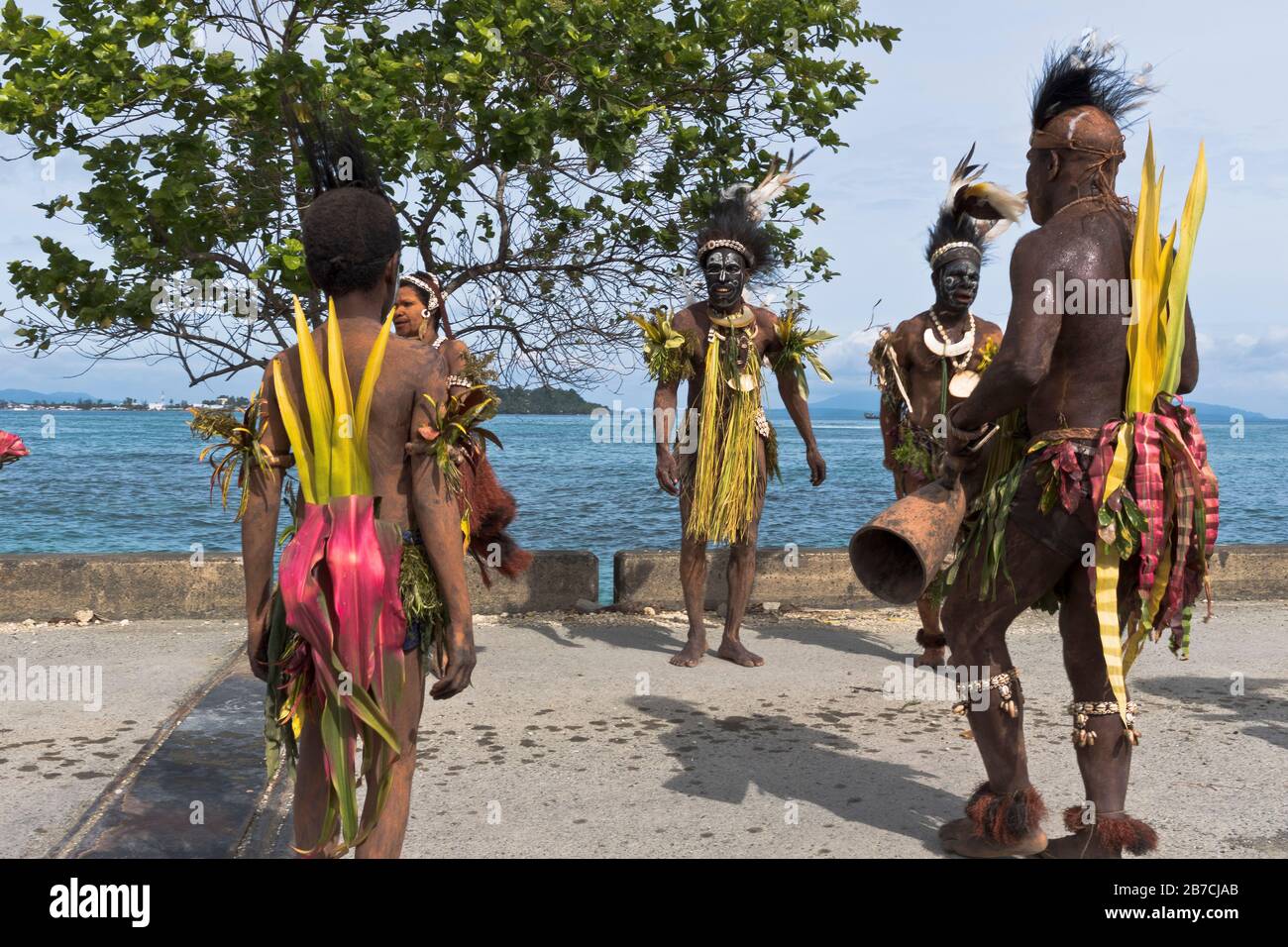 dh Port PNG accueil natif WEWAK PAPOUASIE NOUVELLE GUINÉE batteur traditionnel accueillant bateau de croisière visiteurs personnes tourisme tribal robe groupe culturel Banque D'Images