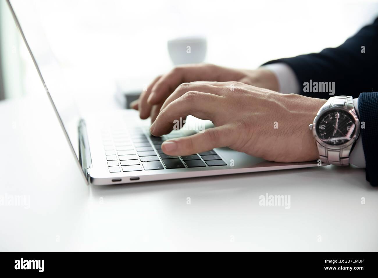 Homme d'affaires réussi à envoyer des SMS sur un ordinateur portable moderne Banque D'Images