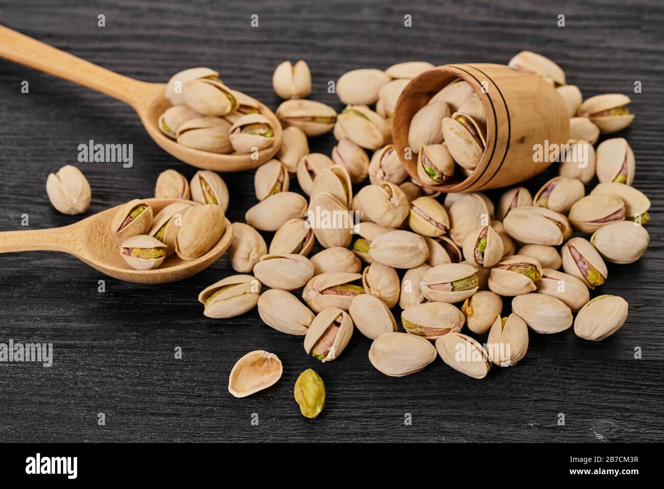 pistaches dans un bol sur fond noir en bois Banque D'Images