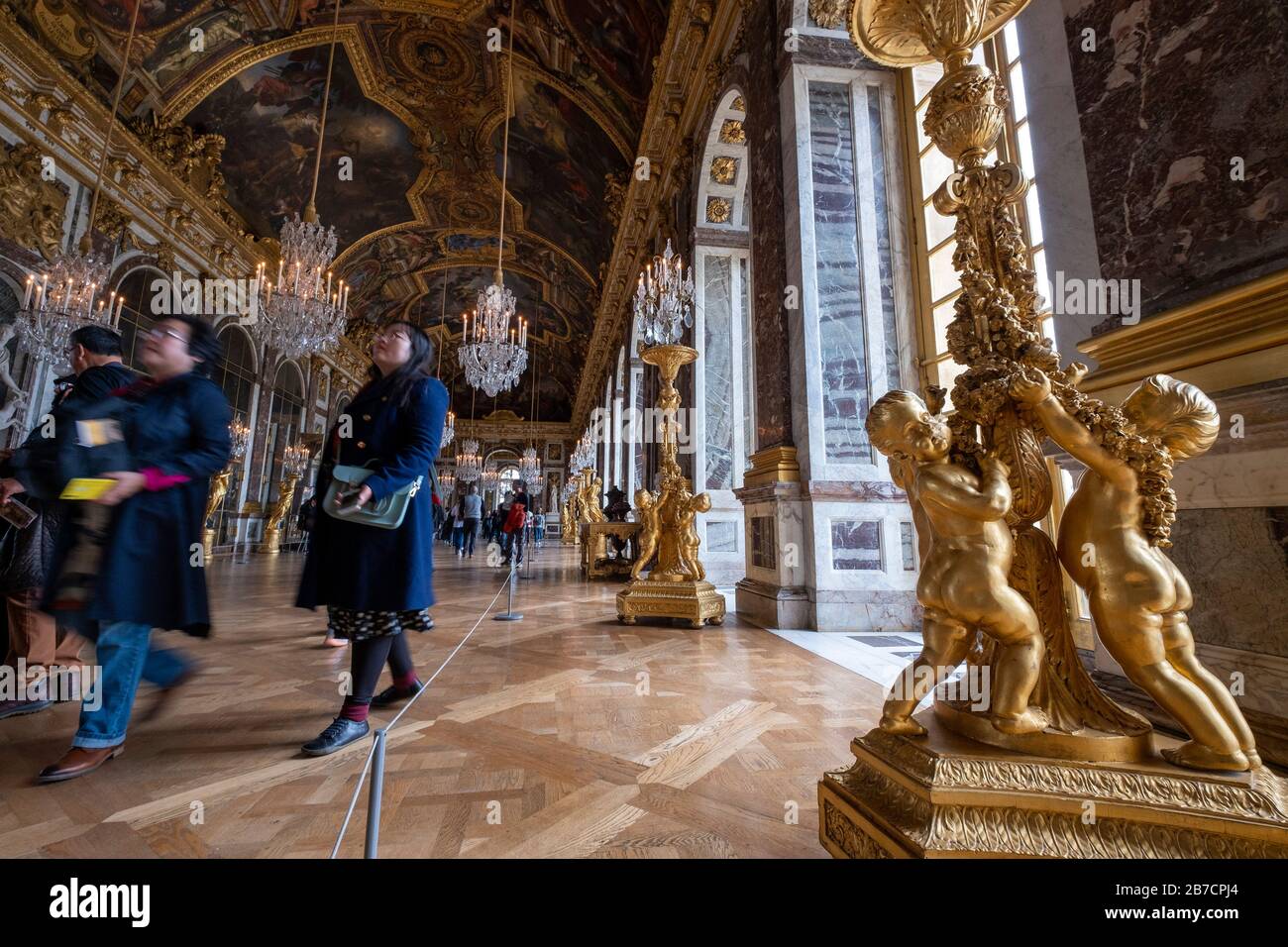 Détail de sculptures dorées au pied d'un candélabre dans la salle de bal de la Galerie des glaces du château de Versailles dans la banlieue de Paris, France Banque D'Images