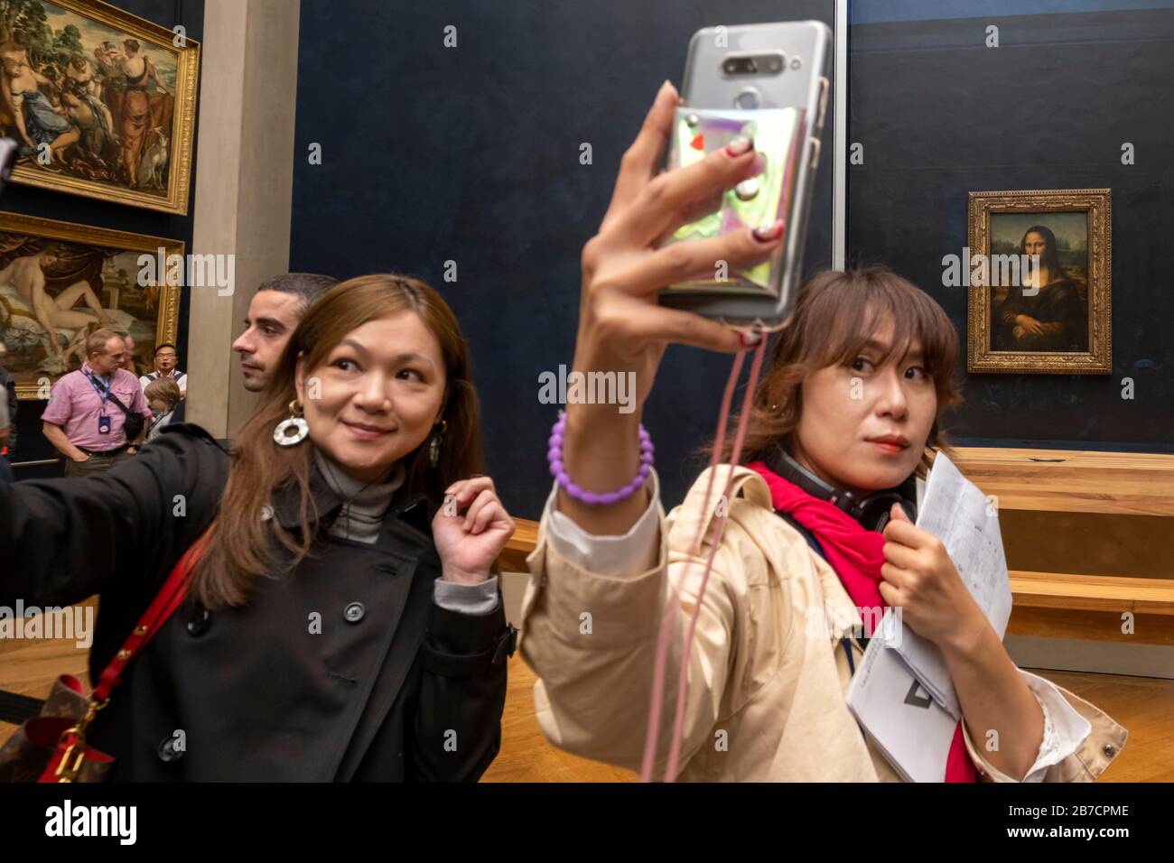 Les touristes asiatiques utilisant leurs smartphones pour prendre des selfies avec la peinture Mona Lisa de l'artiste Leonardo da Vinci, Musée du Louvre, Paris, France, Europe Banque D'Images