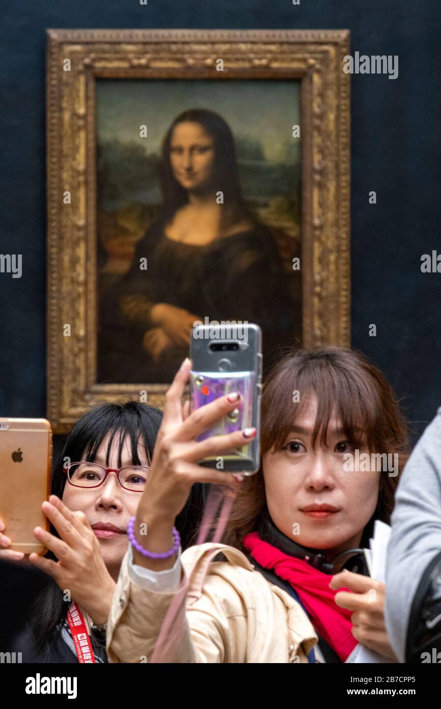 Les touristes asiatiques utilisant leurs smartphones pour prendre des selfies avec la peinture Mona Lisa de l'artiste Leonardo da Vinci, Musée du Louvre, Paris, France, Europe Banque D'Images