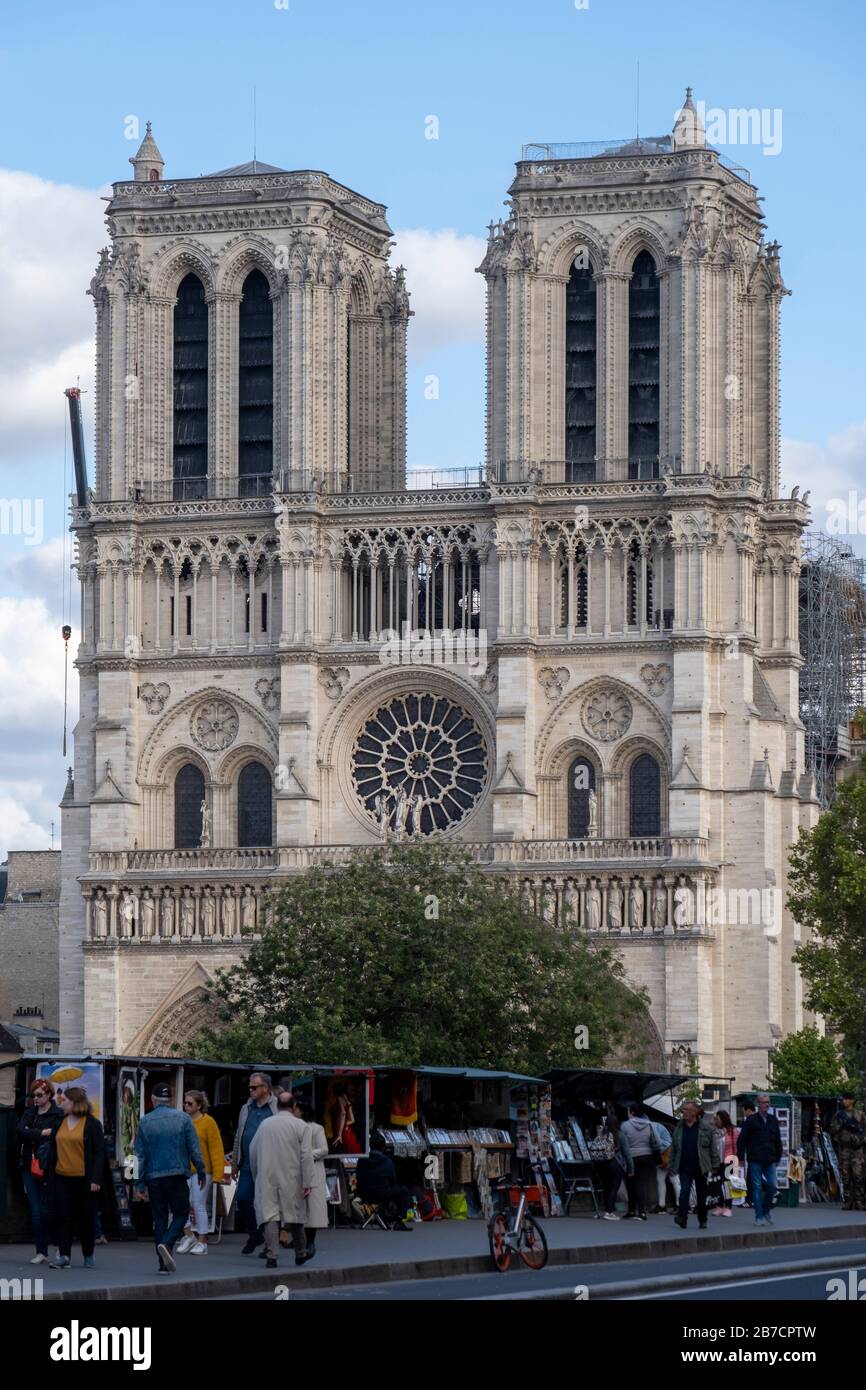 Les personnes passant par des stands de libraires le long de la Seine avec la cathédrale notre Dame en arrière-plan, Paris, France, Europe Banque D'Images