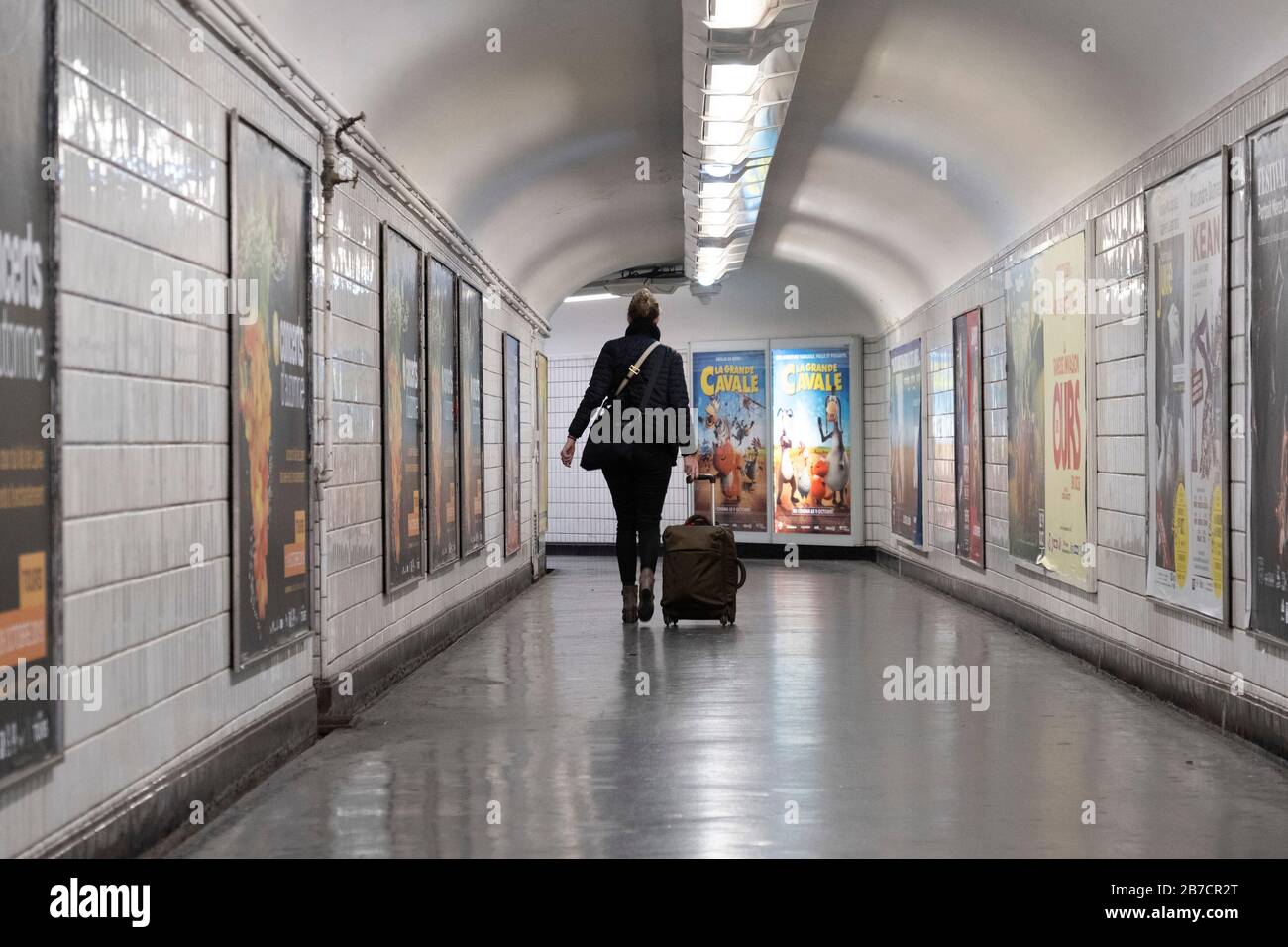 Femme avec valise à roulettes à pied dans le métro parisien de Paris, France, Europe Banque D'Images