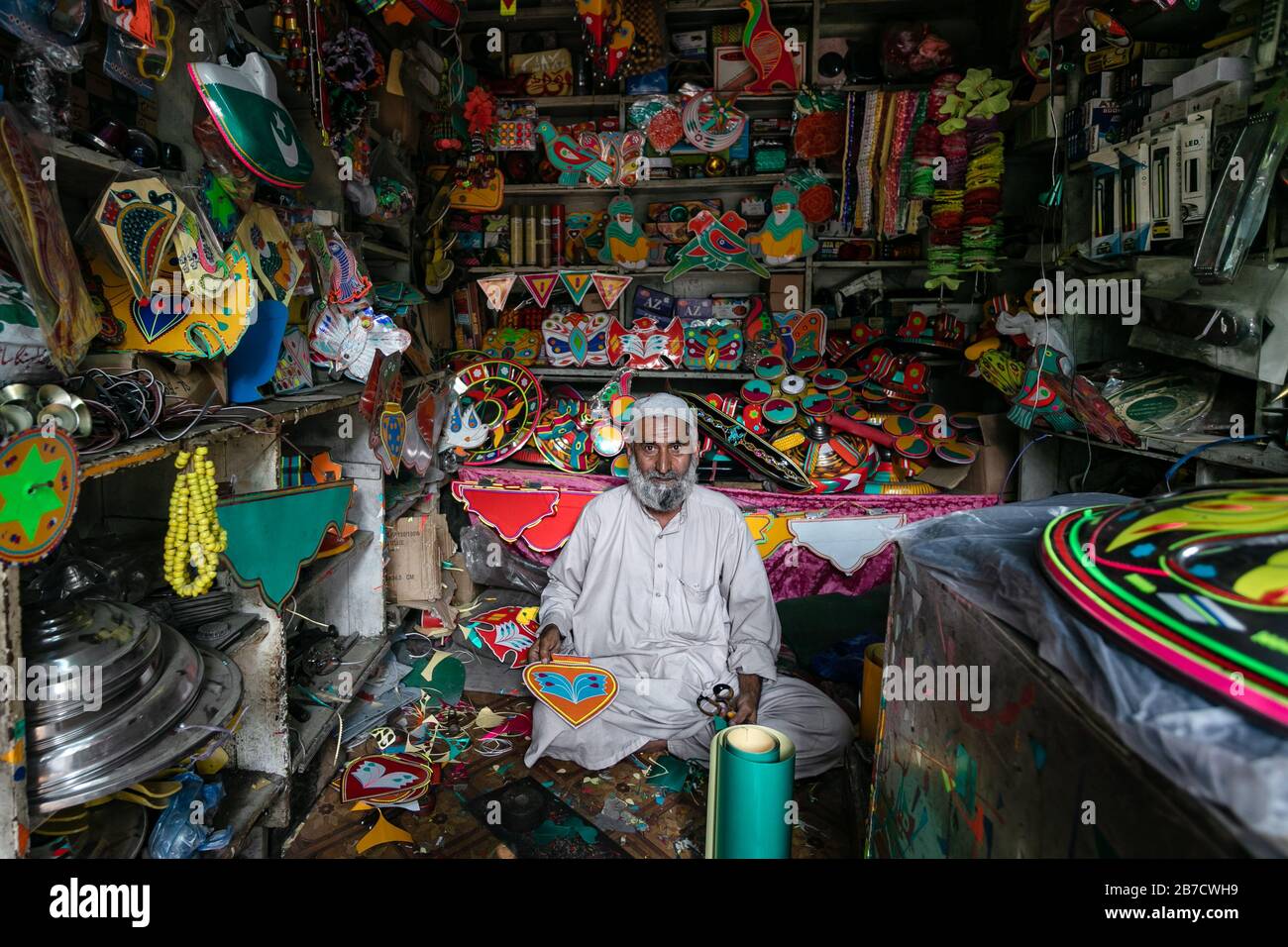 Lahore, Pakistan: Homme vendant des trucs traditionnels de décoration de camion dans la boutique locale Banque D'Images