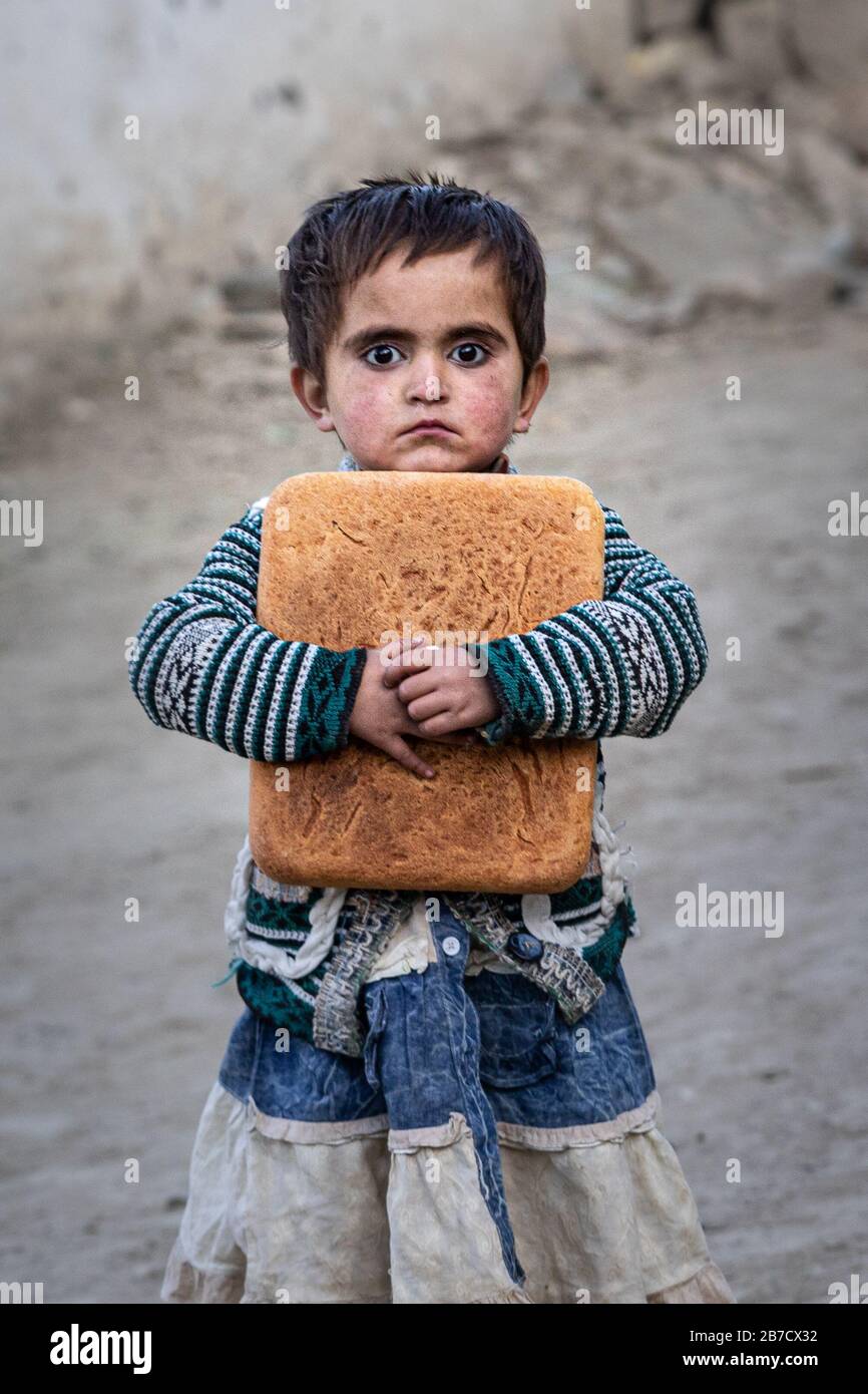 Une fille de réfugiés tenant le village de montagne de pain Pakistan Banque D'Images
