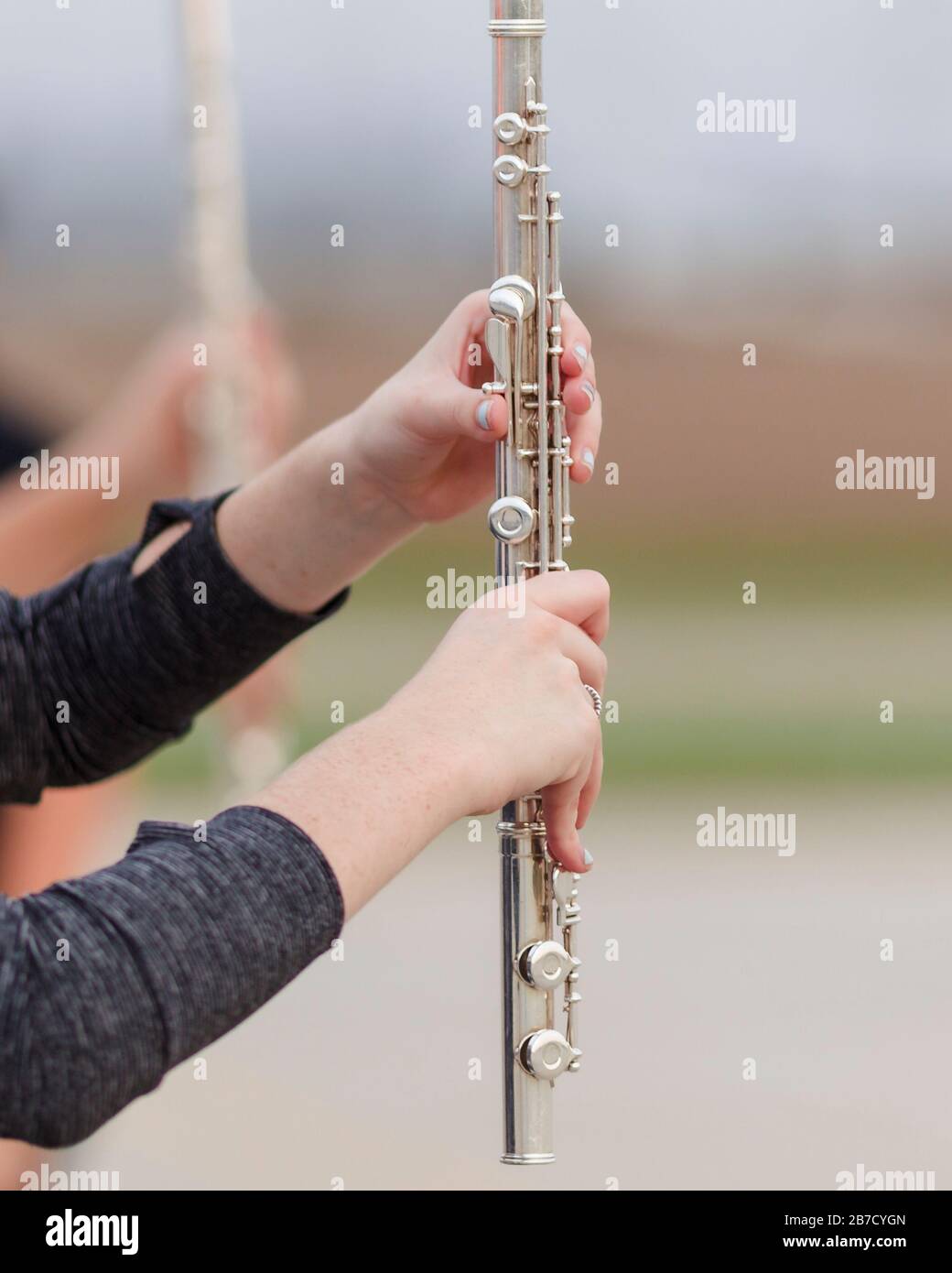 les mains d'un joueur de flûte pendant une répétition de groupe de marchage Banque D'Images