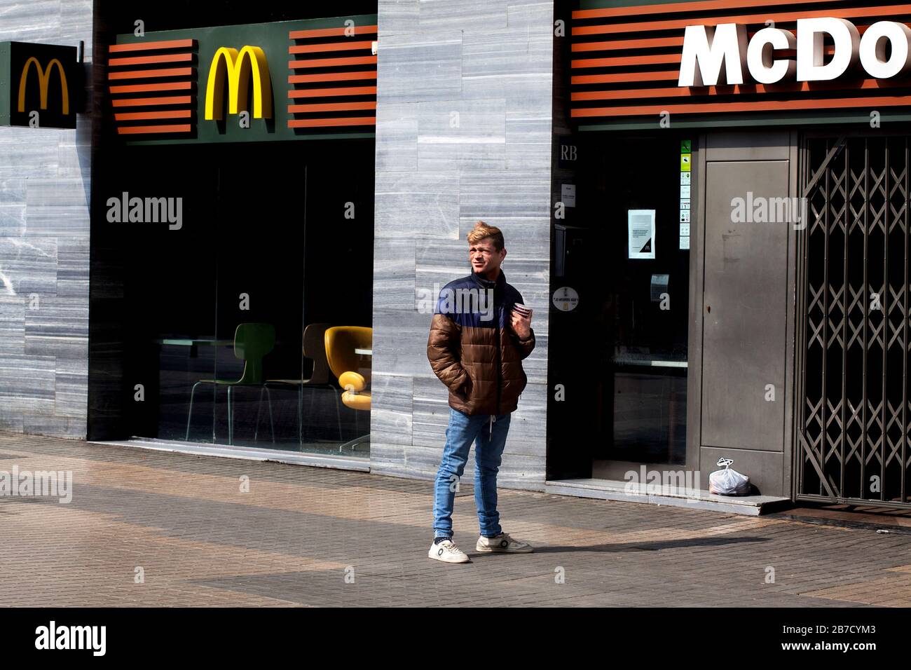 Le mendiant de la région est situé à l'extérieur de la Sagrada Familia McDonalds fermée. Banque D'Images
