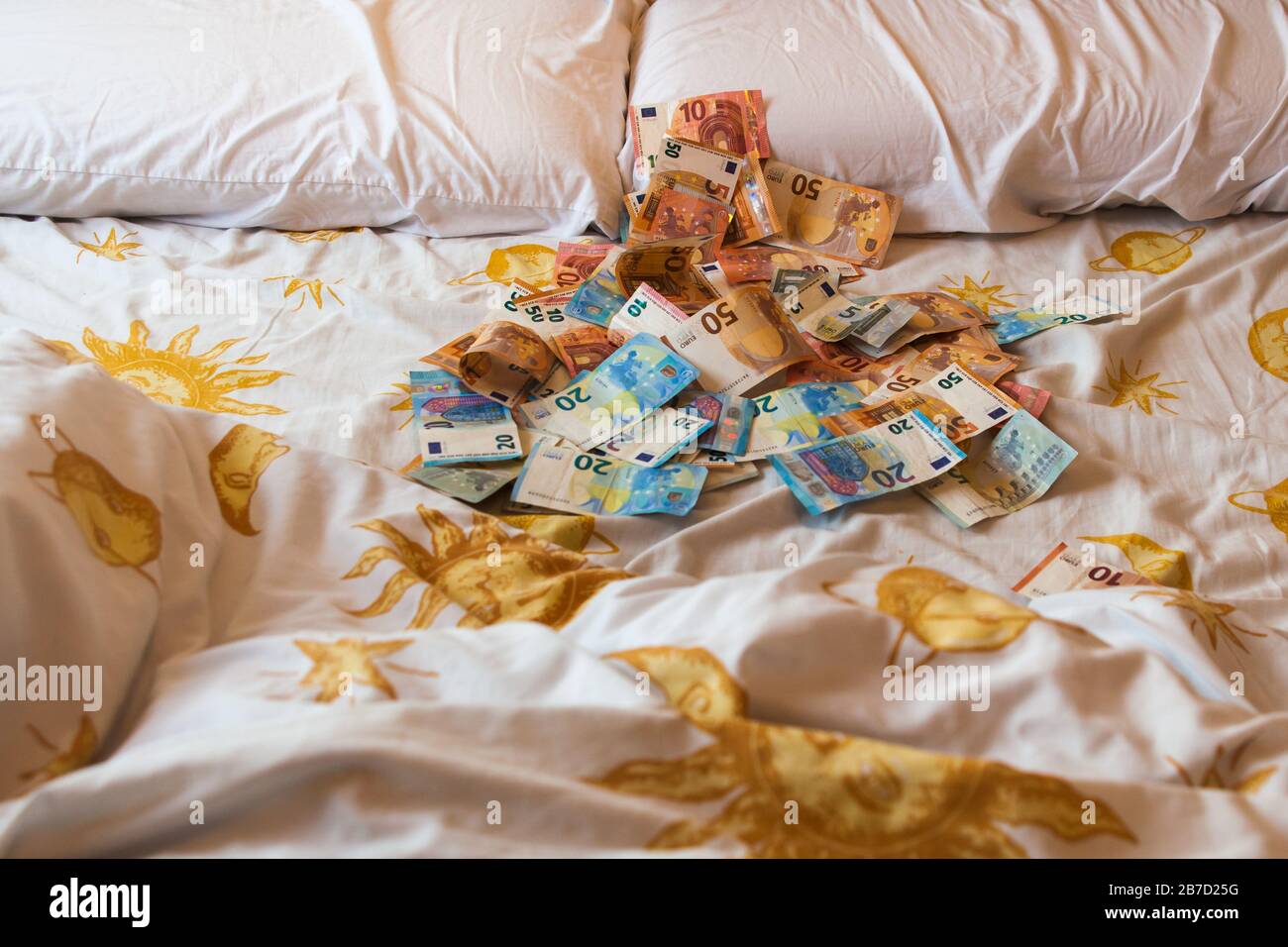 Argent sur le lit, euros, factures et draps Banque D'Images