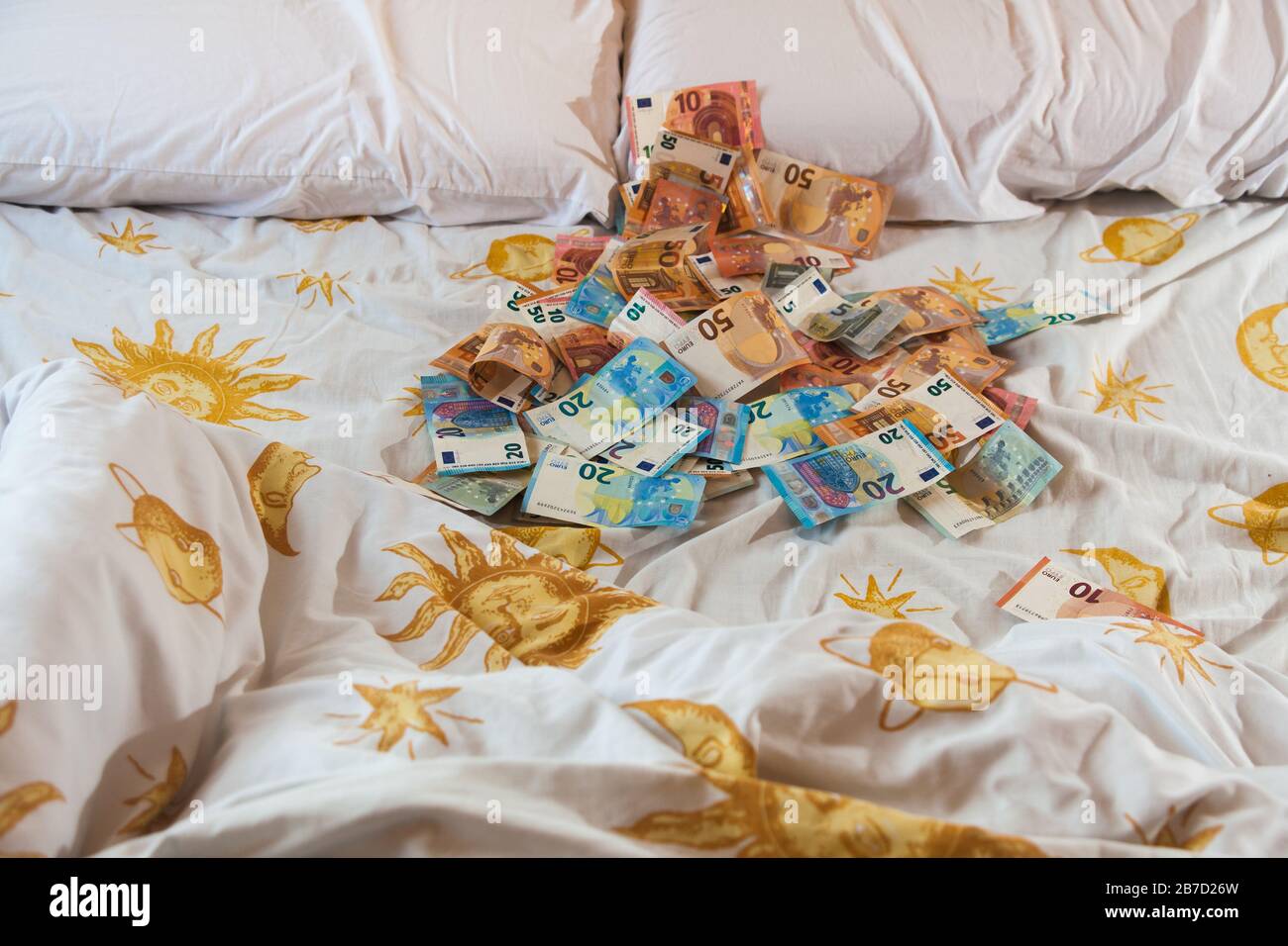 Argent sur le lit, euros, factures et draps Banque D'Images