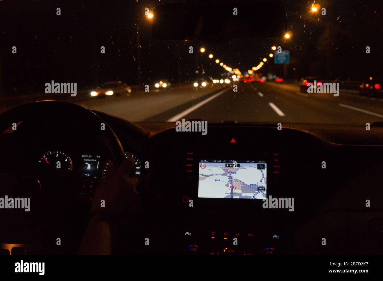 Voiture de conduite la nuit avec navigateur sous la pluie Banque D'Images